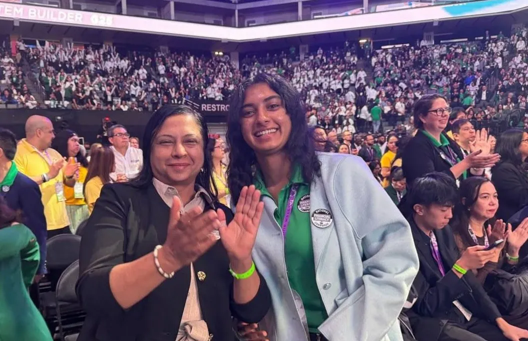 Two team members applauding in the convention crowd