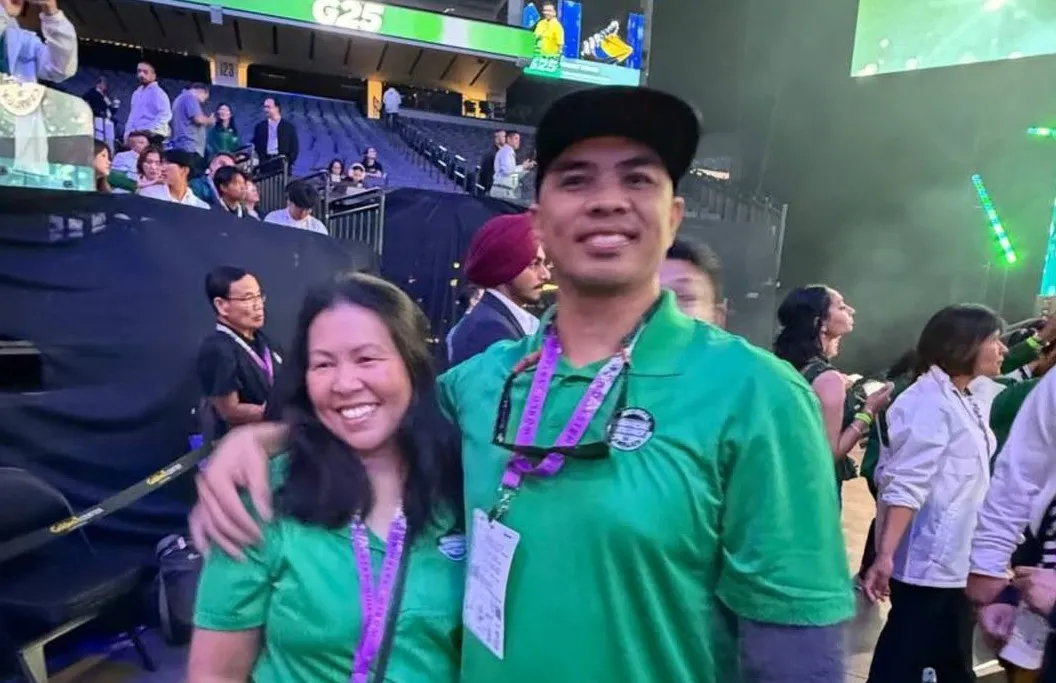 Two team members in matching green shirts on the convention floor