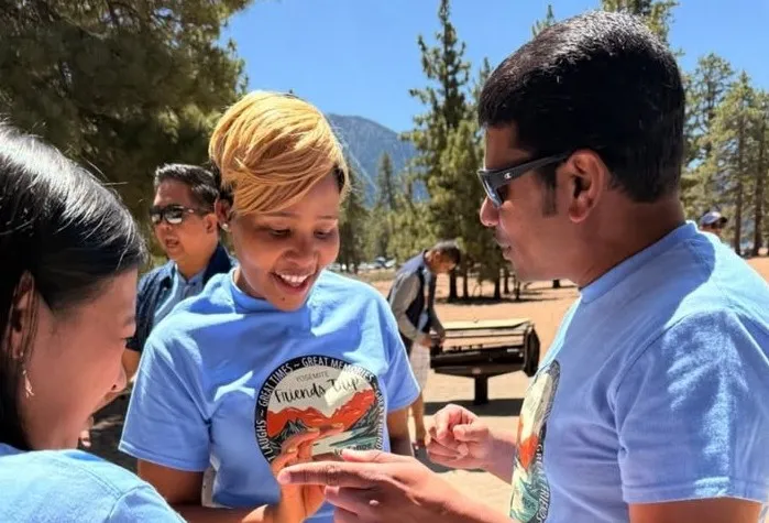 Team members laughing together outdoors in matching retreat shirts